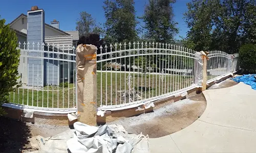 Fence painting project with protective wrapping on posts